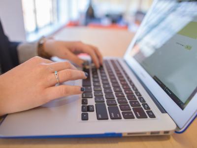 Hands typing at a computer