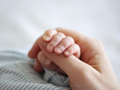 baby hand holding adult finger