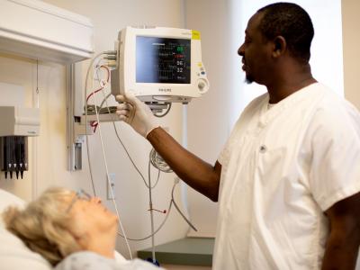 nurse caring for patient in hospital bed