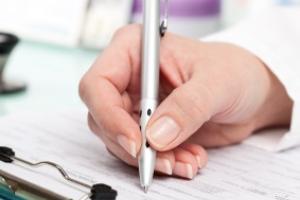 nurse hand writing with a pen to fill out a prescription 