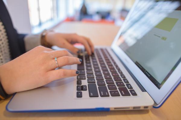 Hands typing at a computer