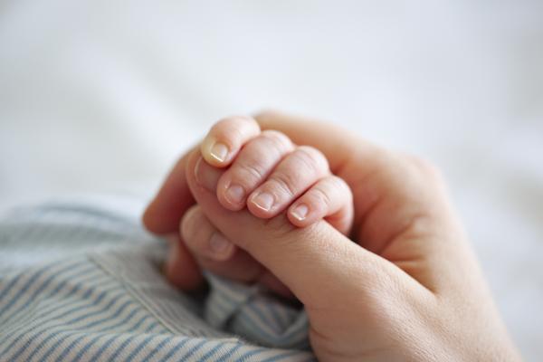 baby hand holding adult finger