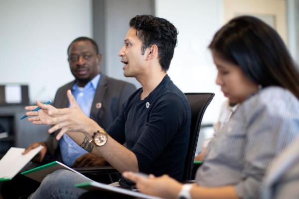 a group of three people, two males and one female, at a meeting having a discussion