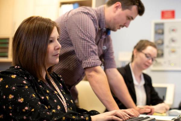 three people at computer