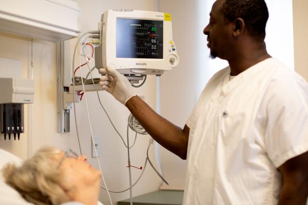 nurse caring for patient in hospital bed